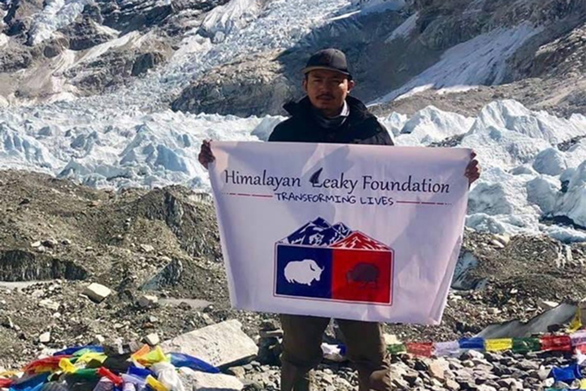 Rabindra holding Himalayan Leaky Foundation flag