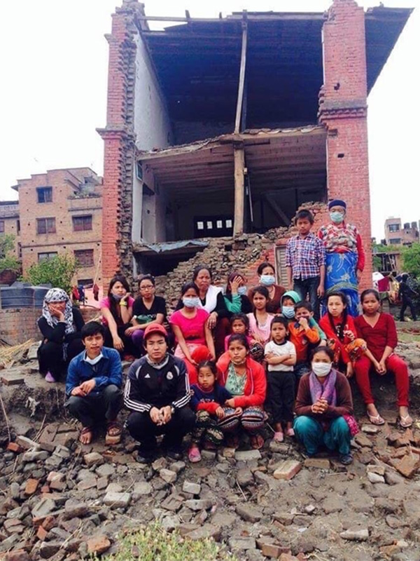 Nepali community sitting in front of collapsed building