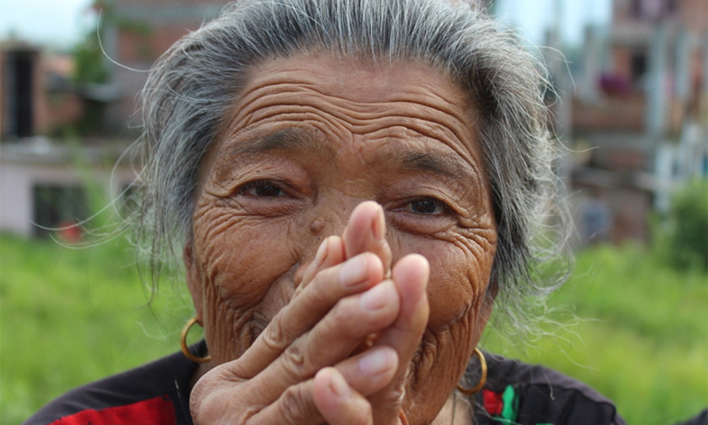 elderly Nepali woman holding hands together